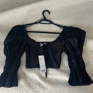 Super cute top! It has puffy sleeves and a tighter, cropped fitting.